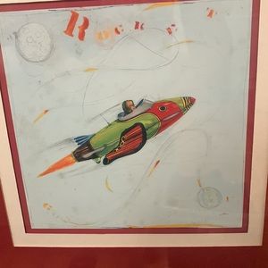 Framed Rocket picture w/mat. Measures approximately 13” x13”.